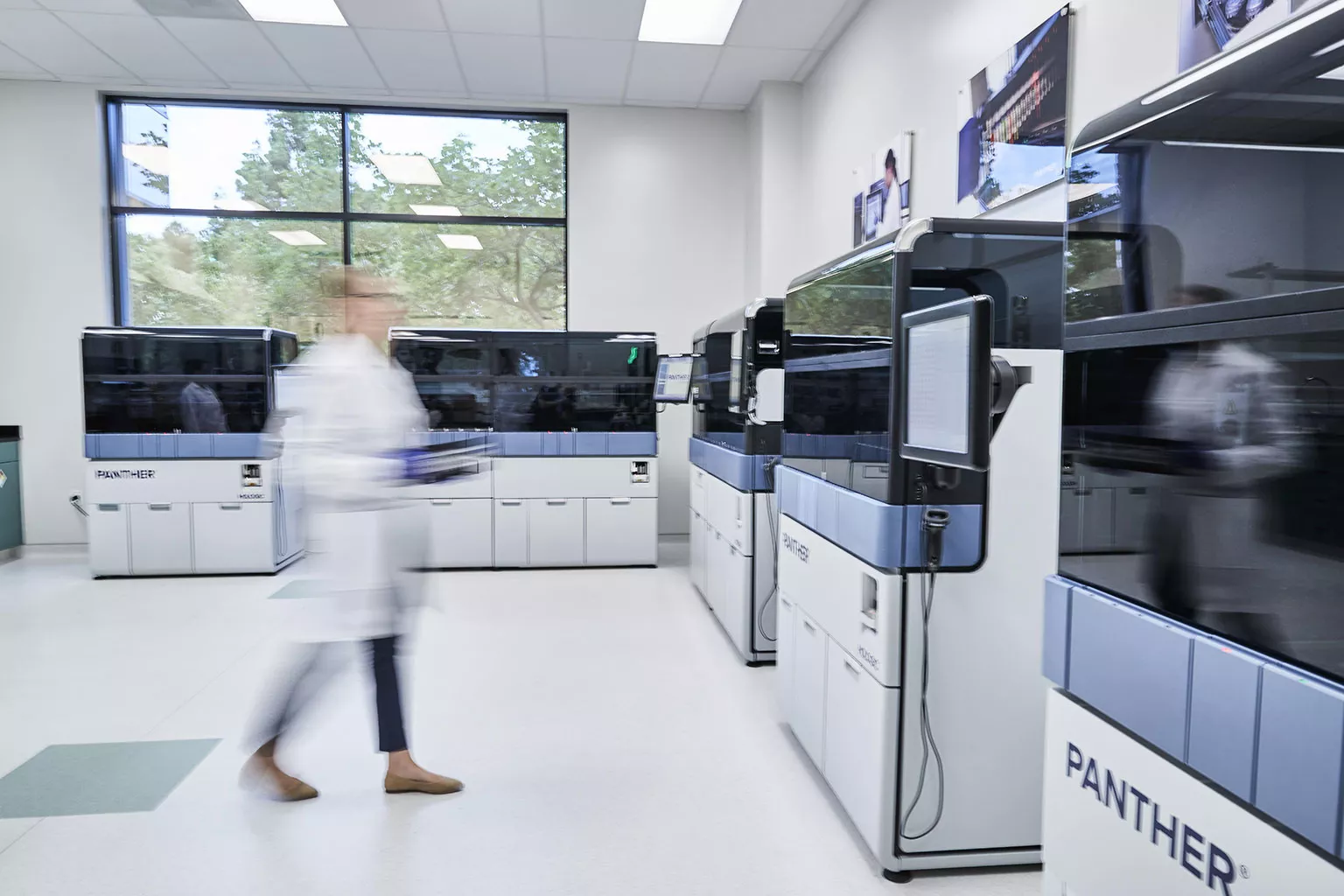 Vrouwelijke laborante loopt door het laboratorium.