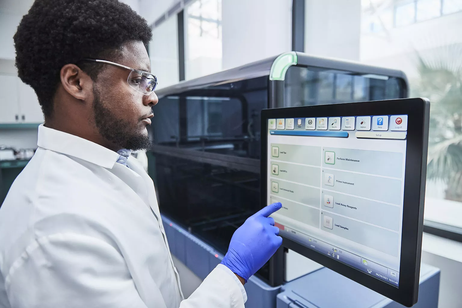 Mannelijke arts raakt beeldscherm van Panther systeem aan in laboratorium.