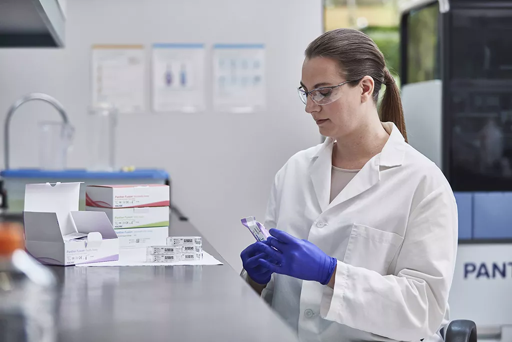 Laborant met meerdere assaydozen met laboratorium op achtergrond