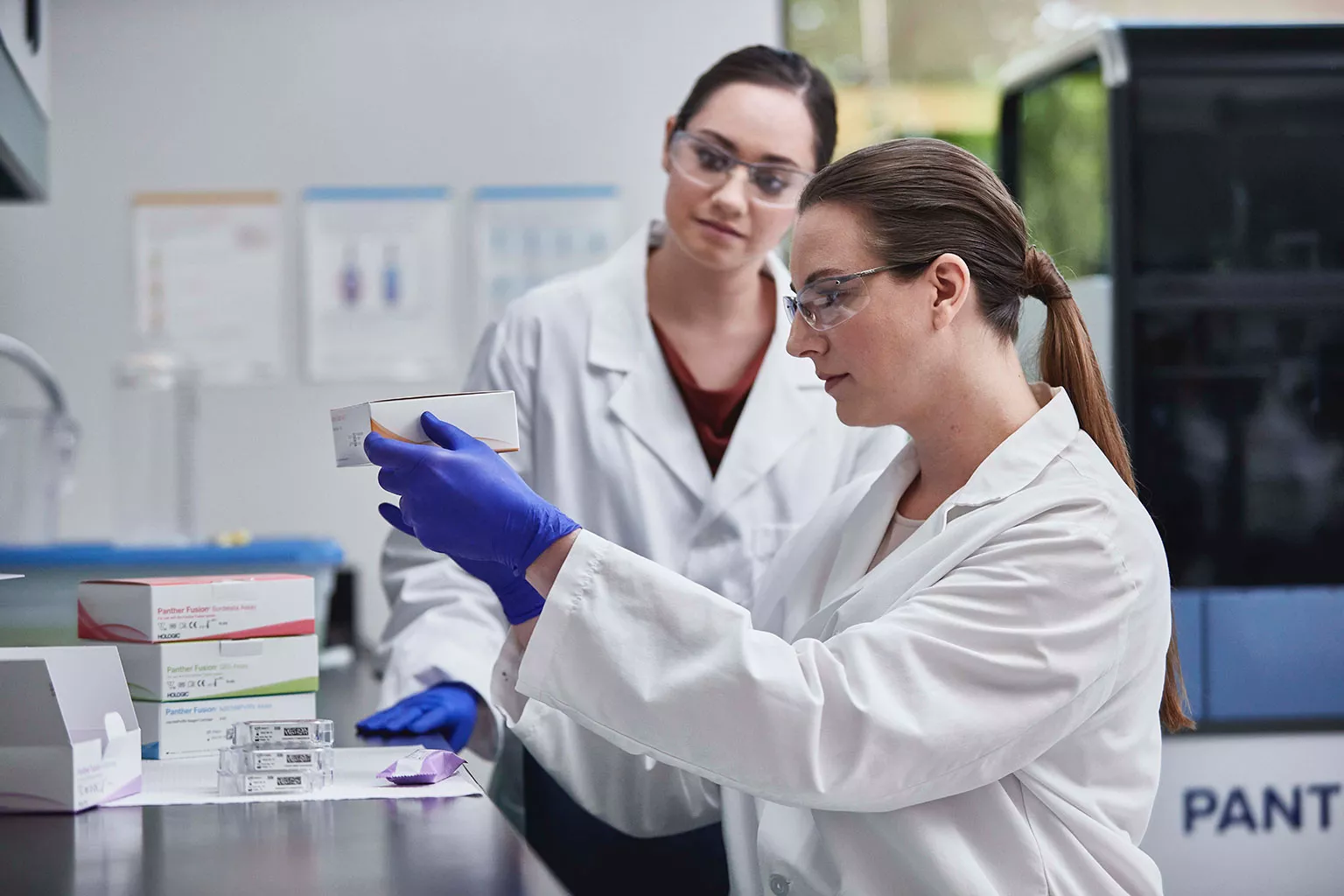 Laboranten houden een assaydoos vast in een laboratorium.