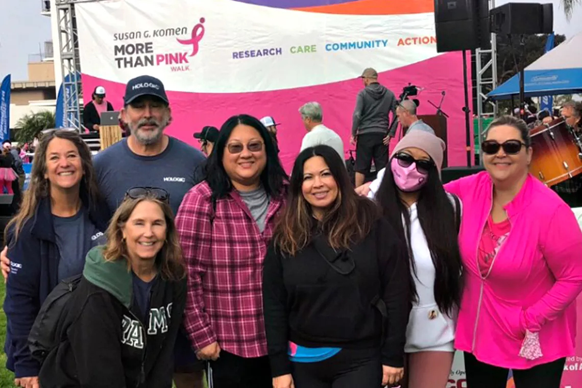 Groepsfoto van lachende mannen en vrouwen tijdens het Susan G. Komen Race for the Cure-wandelevenement
