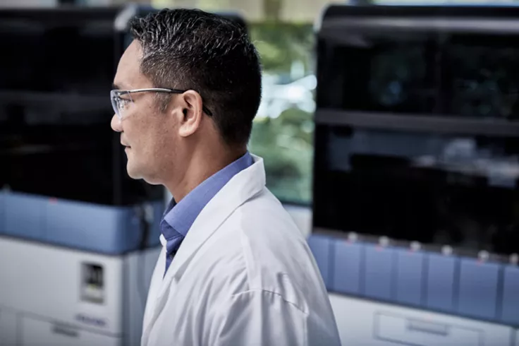 Zijaanzicht van technicus in laboratoriumomgeving met medische systemen